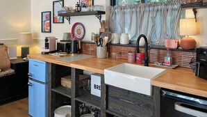 Cocina compacta con pileta, cafetera, tostadora y refrigerador.