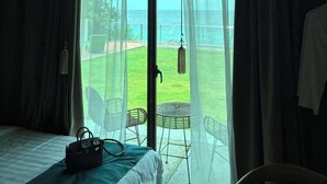 Una habitación de hotel con un ventanal grande, una cama, una silla y una mesa.