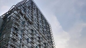 Un moderno edificio de gran altura con fachada de entramado y balcones.