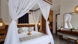 A bedroom with a four-poster bed, wooden headboard, bedside tables with lamps, a vanity with a mirror, and a bench. - Jenna Villa by GenuineHost (Ubud)