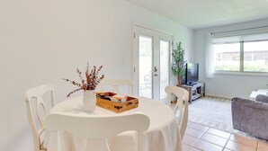 A dining area with a round table, white chairs, a vase with dried plants, and a wooden box. - 2 Mi to Old Town & Fashion Sq: Townhome w/ Pools (Scottsdale)