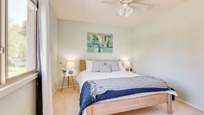 A bedroom with a bed, a ceiling fan, a window with curtains, a painting on the wall, and two bedside lamps. - 2 Mi to Old Town & Fashion Sq: Townhome w/ Pools (Scottsdale)