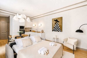Une chambre d’hôtel moderne avec un lit, une table de chevet et un tableau.