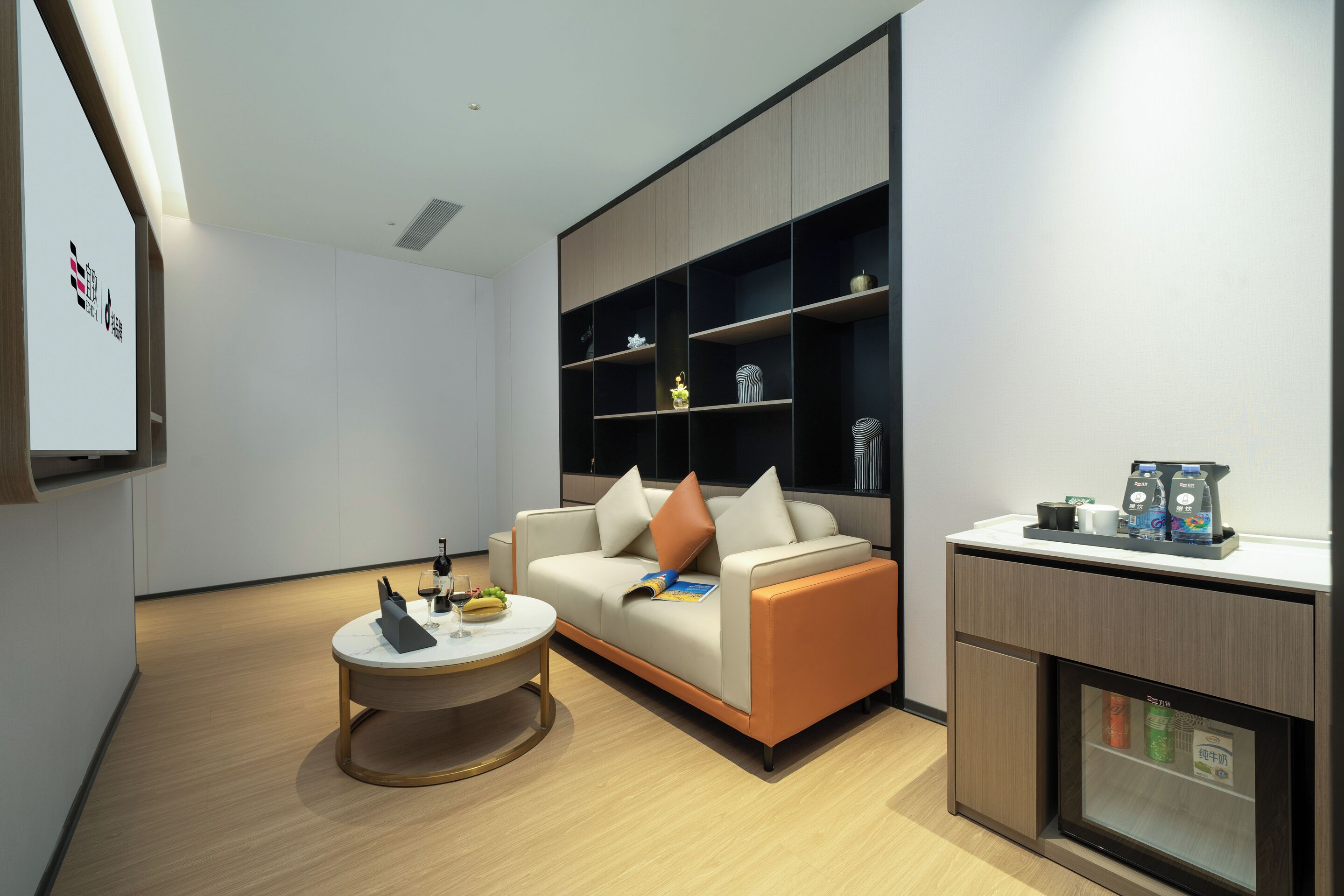A modern living room with a sofa, coffee table, and built-in shelving.