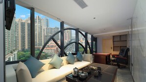 A modern living room with a sofa, coffee table, and city view. - Yizhi Hotel Shamian Pearl River Night Cruise-Canton Fair free shuttle bus included free Breakfast&Gym&Laundry&free coffee allday (Guangzhou)