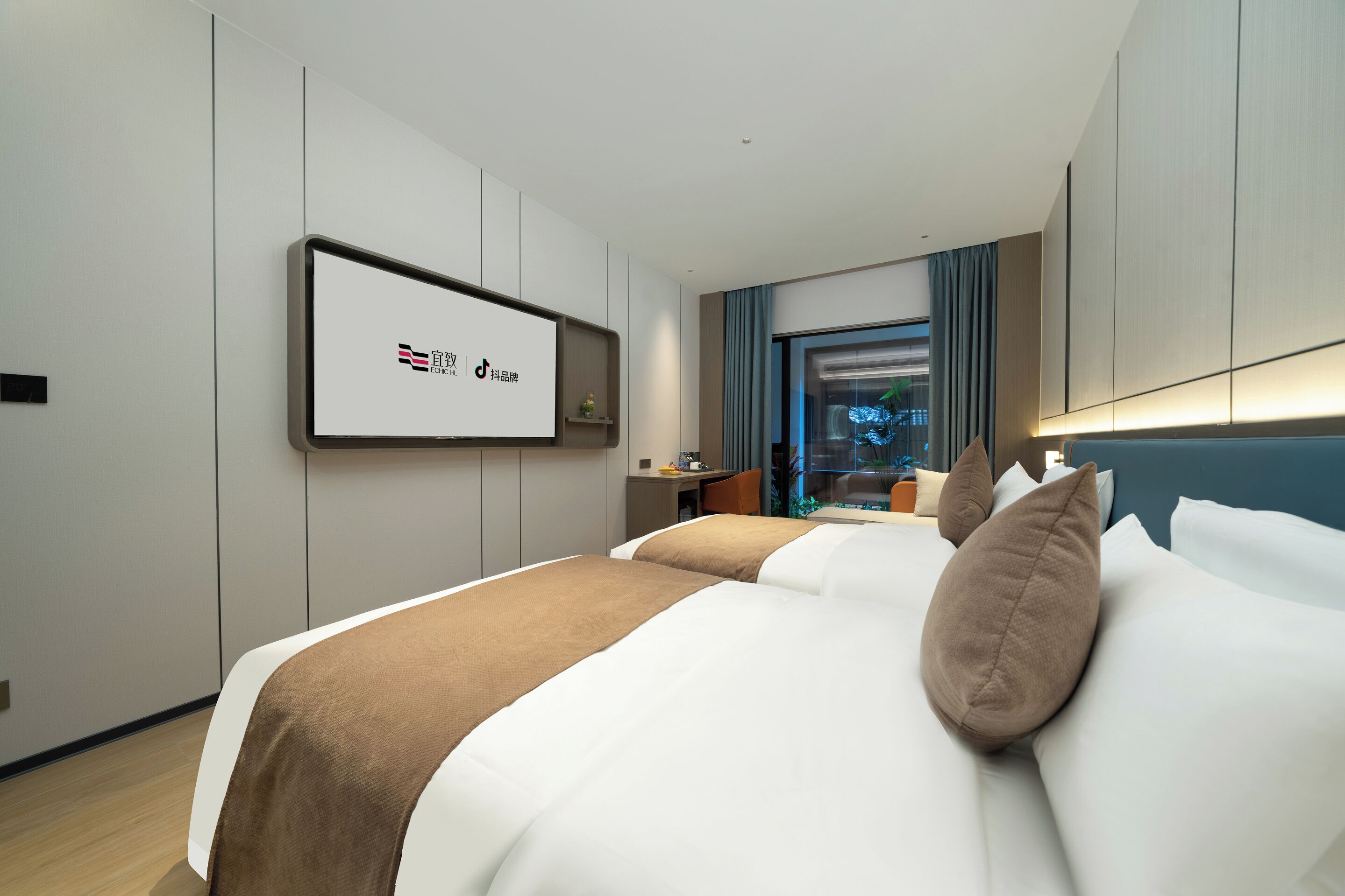 A hotel room with a bed, a desk, and a television mounted on the wall.