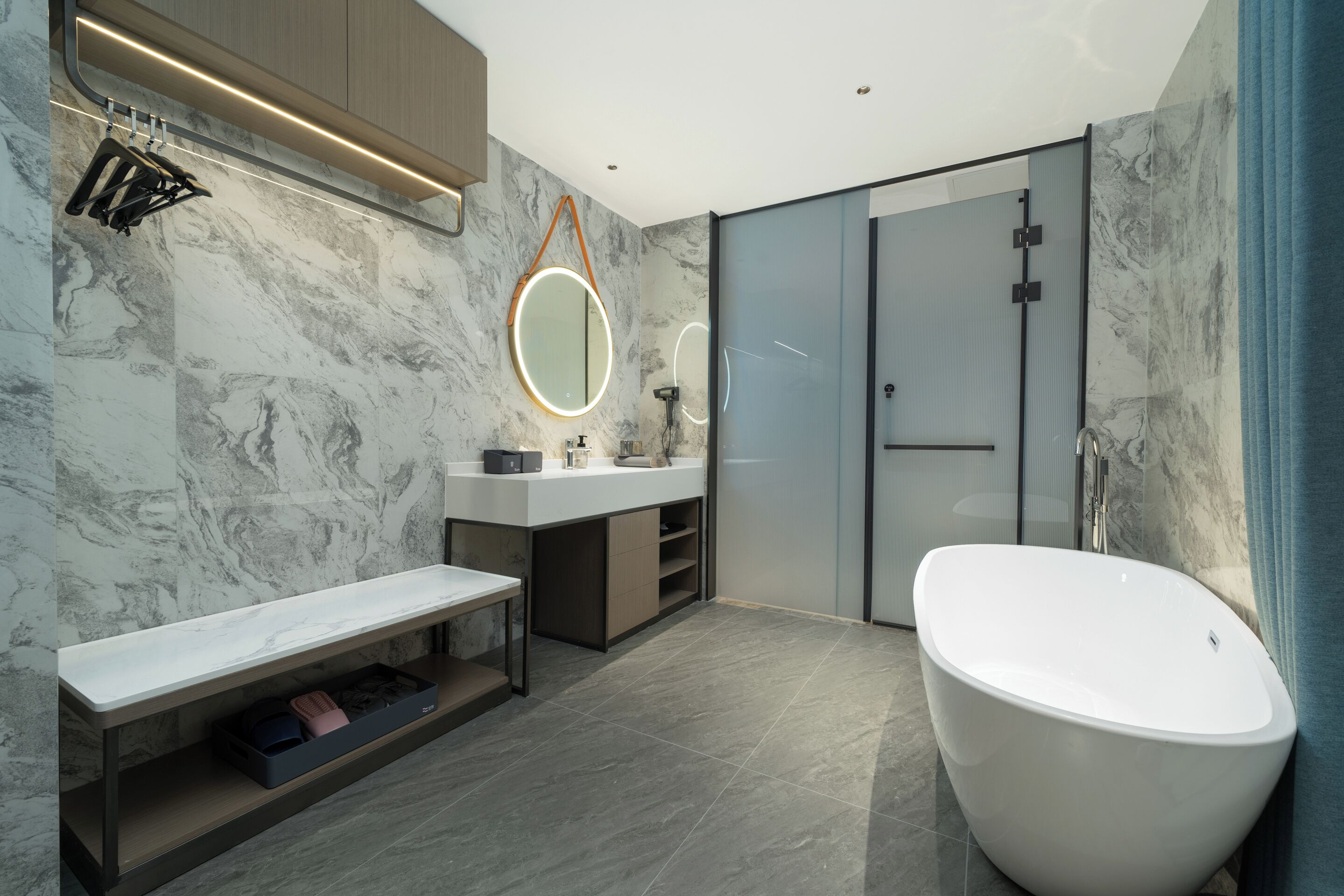 A modern bathroom with a freestanding bathtub, a vanity with a mirror, and a shower area.