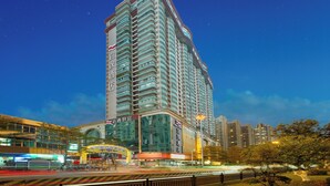 A high-rise hotel with multiple balconies, a large glass facade, and signage indicating amenities. - Yizhi Hotel Shamian Pearl River Night Cruise-Canton Fair free shuttle bus included free Breakfast&Gym&Laundry&free coffee allday (Guangzhou)
