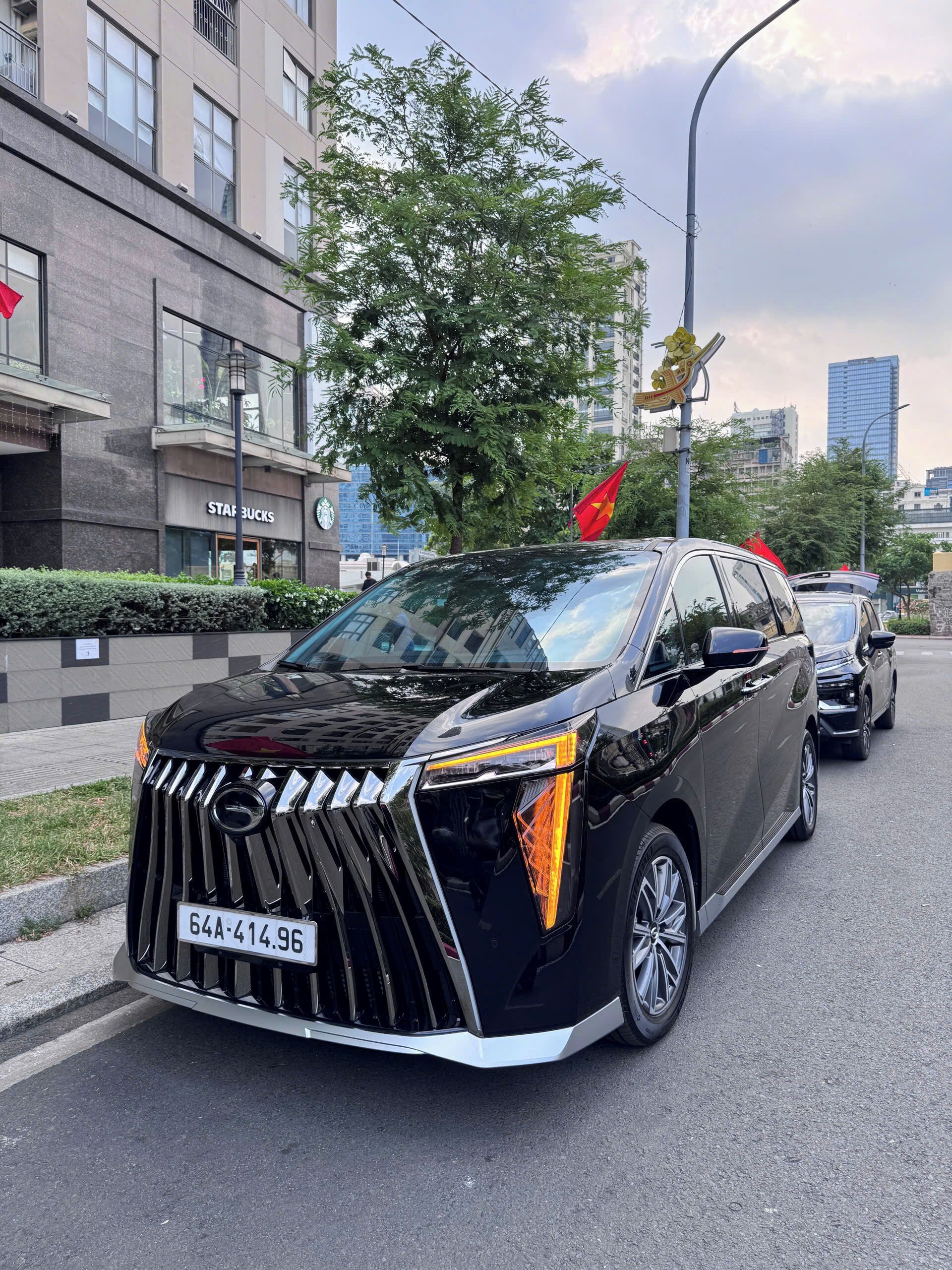 Un SUV negro estacionado en una calle de la ciudad, con un letrero de Starbucks al fondo.