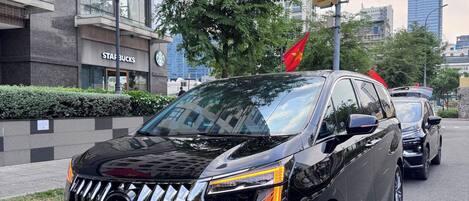 Un SUV negro estacionado en una calle de la ciudad, con un letrero de Starbucks al fondo.