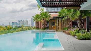 Una piscina al aire libre, sombrillas, tumbonas