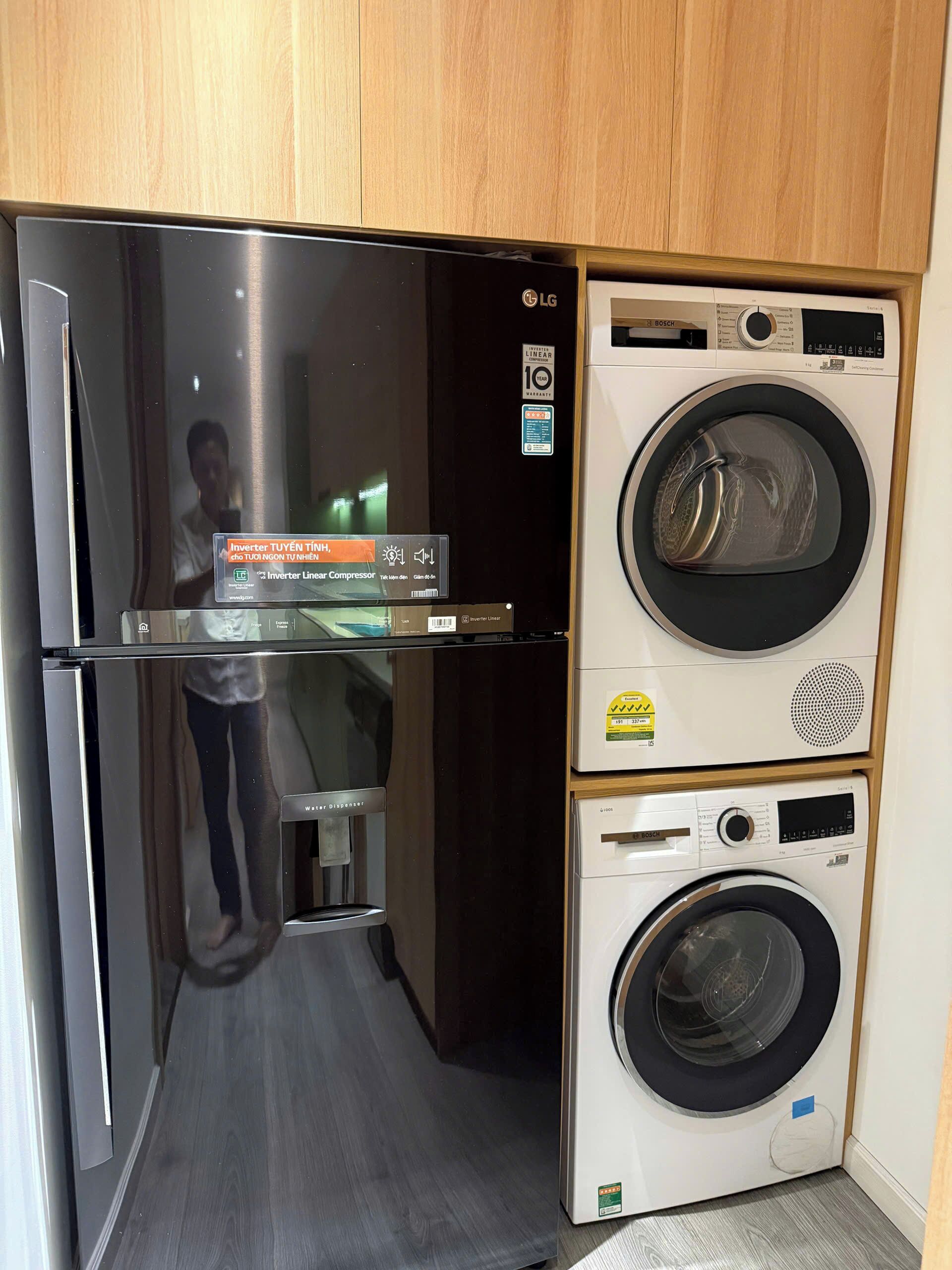 A compact kitchen with a refrigerator, a Bosch washing machine, and a Bosch dishwasher.