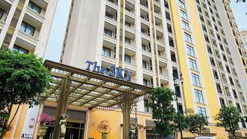A high-rise hotel with a prominent entrance and a name sign.