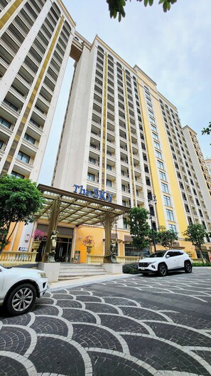 A high-rise hotel with a prominent entrance and a name sign. - Aura Apartment (Phu Quoc)