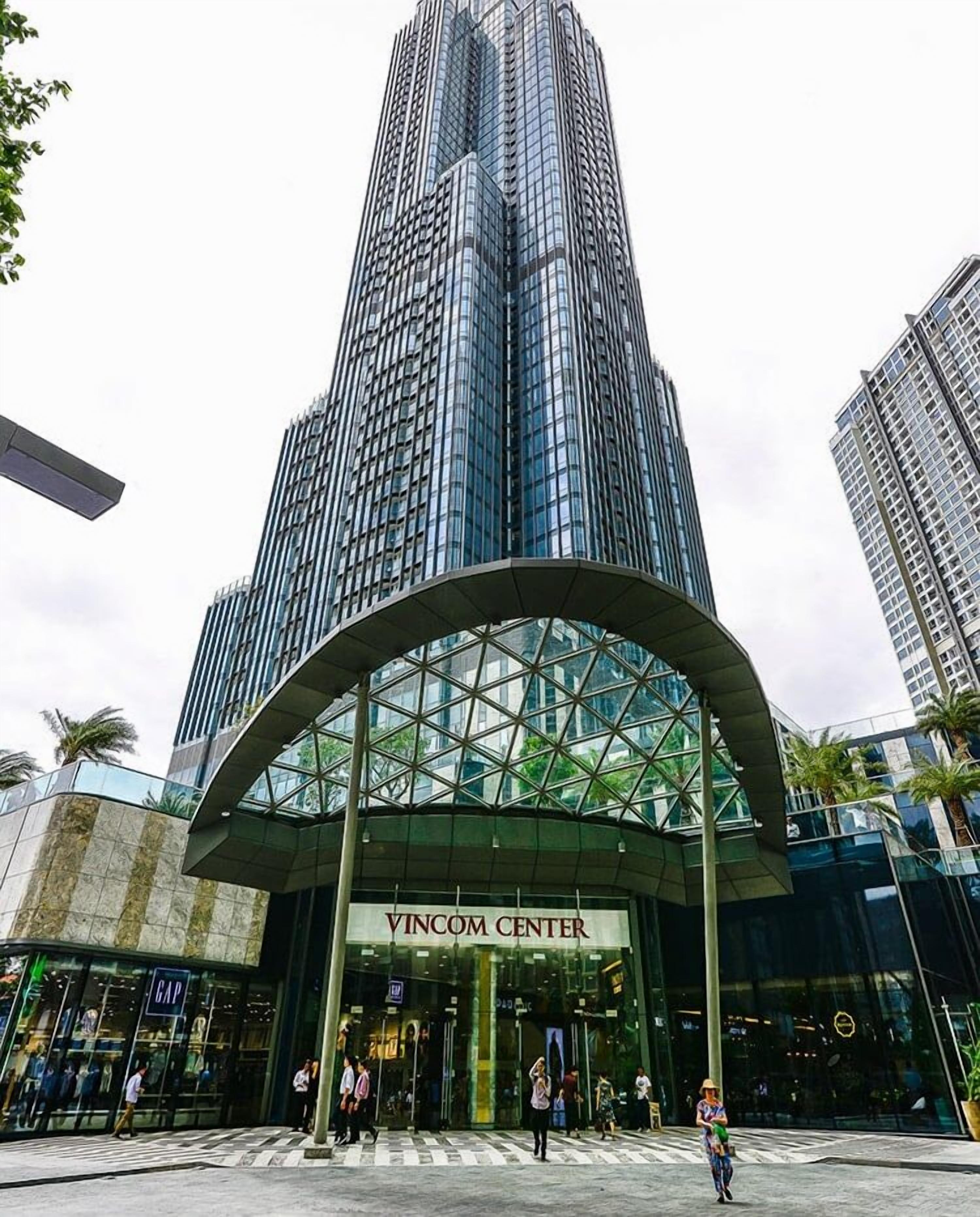A modern building with a curved glass entrance labeled "VINCOM CENTER".