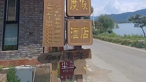 A signpost with multiple directional signs and a contact number.