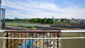 Un edificio de gran altura con vistas a un paisaje urbano, que incluye un río y zonas verdes.