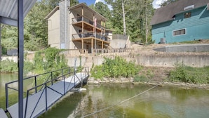 A multi-story building with balconies, a dock, and a pond. - Fire Pit + Private Dock: Ozarks Family Escape! (Camdenton)