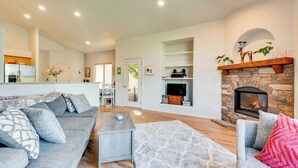 A modern living room with a grey sofa, a coffee table, and a fireplace. - Pet-Friendly Longmont Home w/ McIntosh Lake Access (Longmont)