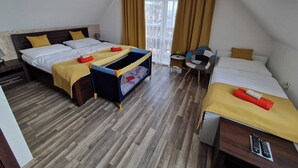 A hotel room with two beds, a small table, a chair, a window with curtains, and a ceiling lamp. - Soothing 4-bedroom villa in Bešenová (Bešenová)
