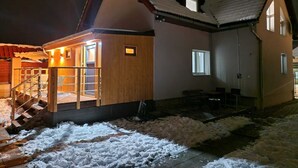 A wooden cabin with a sloped roof, a small porch, and a staircase leading to the entrance. - Soothing 4-bedroom villa in Bešenová (Bešenová)