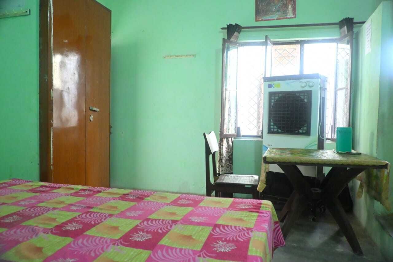 Une pièce comprenant un lit, une table, une chaise et un climatiseur.