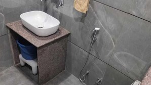 A bathroom with a white sink, a toilet, and a shower. - Hotel River View Panipat (Panipat)