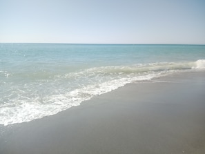 Una playa con agua cristalina y olas suaves.