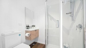 Une salle de bain moderne équipée de toilettes, d’un lavabo et d’une douche.