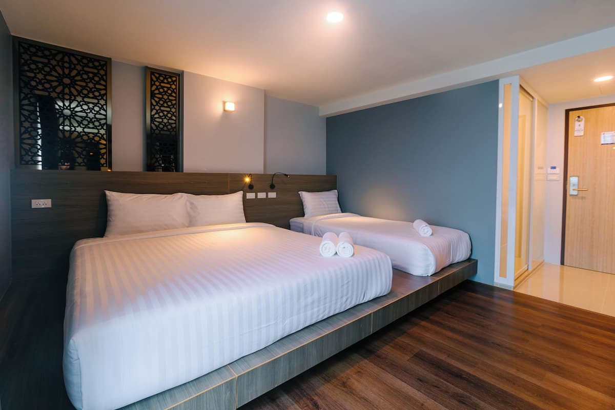 Ein Hotelzimmer mit zwei Betten, Holz-Kopfteilen und modernem Design.