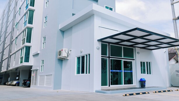 A modern building with a covered entrance and multiple windows. - One Budget Hotel Chiangrai Soi Sawan (Chiang Rai)