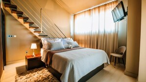 A bedroom with a bed, a nightstand, a lamp, a chair, a TV, and a staircase. - Villa Marid Opatija (Opatija)