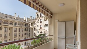 A balcony with a railing, a white table, and a chair.