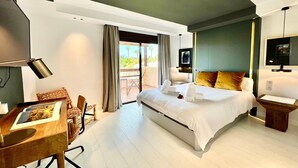 Una habitación de hotel moderna con una cama grande, un escritorio y un rincón de comedor.