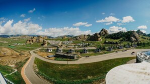 A residential area with houses, a curved road, and a large building with a dome-like structure. - Premium Bolor Resort Terelj (Ulaanbaatar)