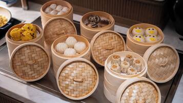 A variety of dim sum dishes in woven bamboo baskets.