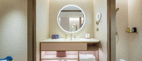 A modern bathroom with a round mirror, a sink, and a shower area.