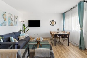 Ein modernes Wohnzimmer mit einer Couch, einem Couchtisch, einem Esstisch und Stühlen.