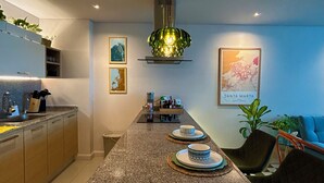 A modern kitchen with granite countertops, a central island, and a hanging light fixture. - Corozo Berry Loft - Mallorquin View. One block from Buenavista. (Barranquilla)