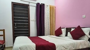 A bed with a white and red bedspread, two pillows, and a wooden headboard. - HOTEL TRIMURTI INN (Lucknow)
