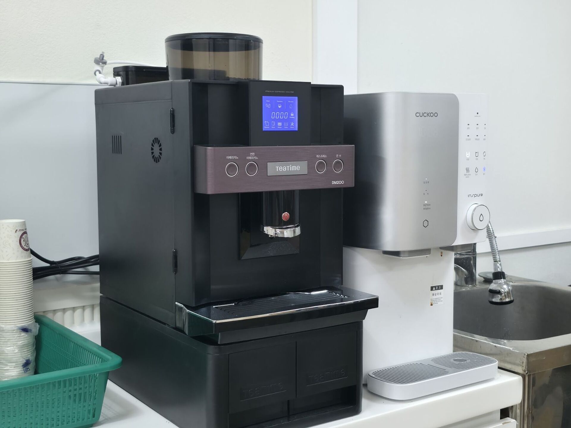 Une machine à café dotée d’un écran numérique, d’un distributeur d’eau et d’un porte-tasse.