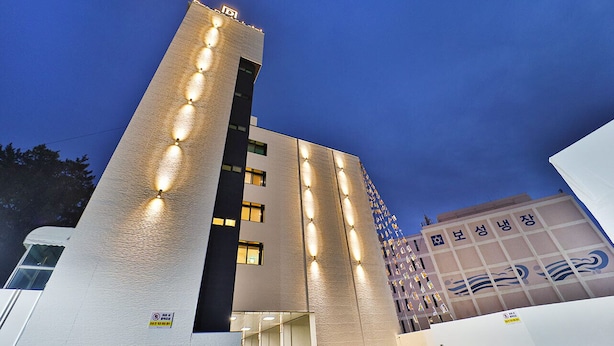 A modern hotel with a prominent tower and a building with a wave design. - SongDODenbastaHotel (Busan)