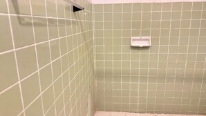 A bathroom with green tiled walls and a white sink.