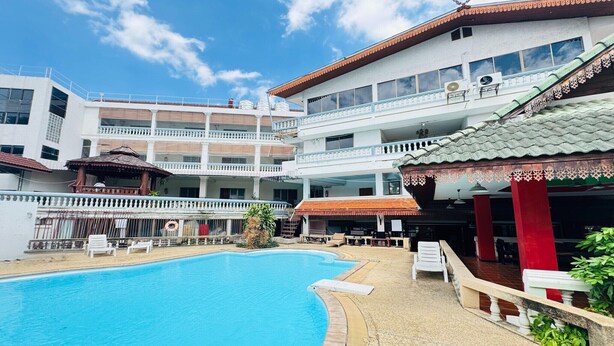 A hotel with a swimming pool, outdoor seating, and a multi-story building with balconies. - Value Twin Stay | Cozy & Convenient Retreat (Chiang Mai)