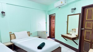 A hotel room with a bed, a small desk, a mirror, and a wardrobe. - Value Twin Stay | Cozy & Convenient Retreat (Chiang Mai)