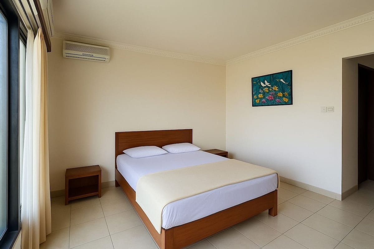 A neatly arranged hotel room with a bed, bedside tables, a painting, and a door.