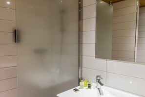 A modern bathroom with a glass shower enclosure, a white sink, and a large mirror. - Delightful apartment in Saint Chaffrey (SAINT CHAFFREY)