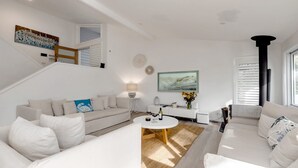 Ein modernes Wohnzimmer mit Sofa, Couchtisch und Kunstwerken.