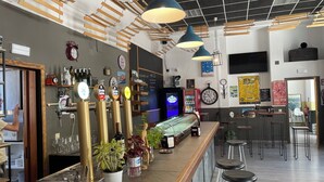 A bar area with multiple beer taps, a glass display case, and bar stools. - El Vagón Bar-Albergue Béjar (Béjar)