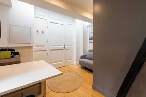 A modern living room with a sofa, a coffee table, and a dining area with a table and chairs.